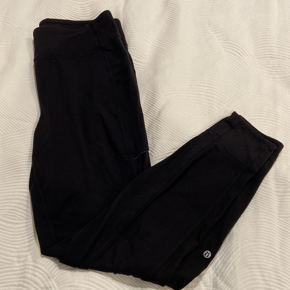 Black lululemon pants with side zip pocket and tapered bottom